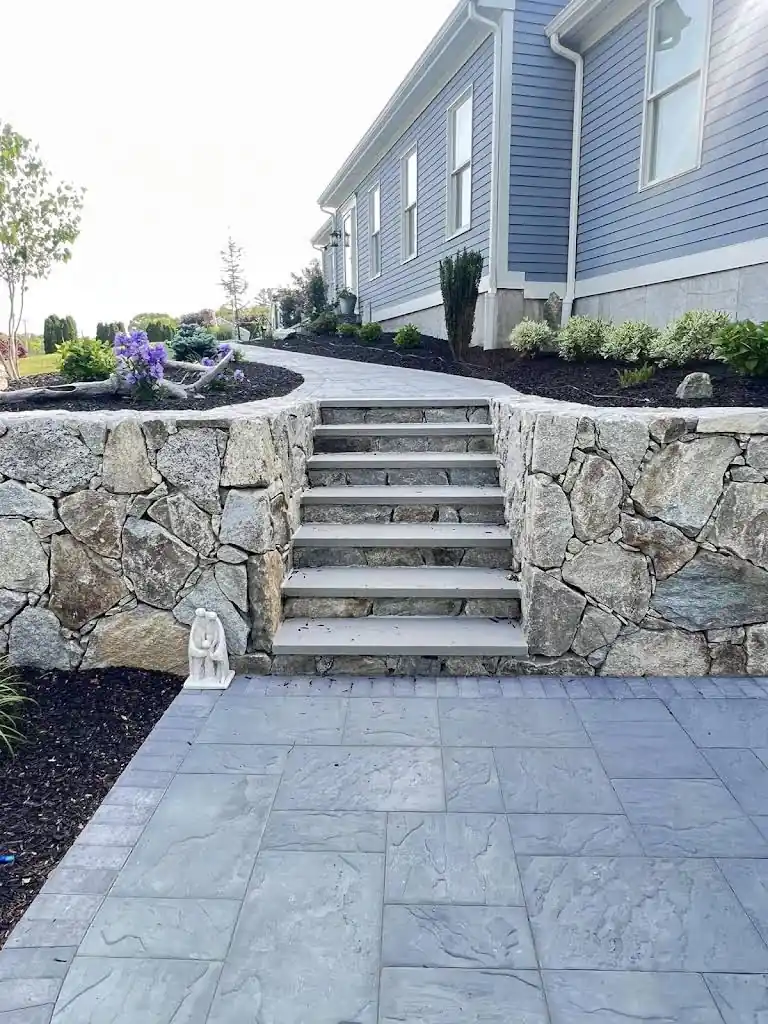 Granite steps flanked by stone retaining walls — patio installation Johnston Rhode Island