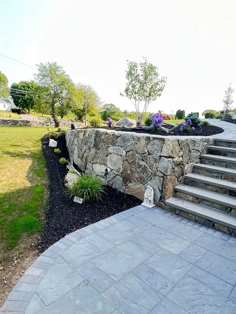Patio walkway with stone retaining wall and granite steps in Johnston, Rhode Island